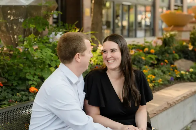 Laughing together on a downtown planter bench