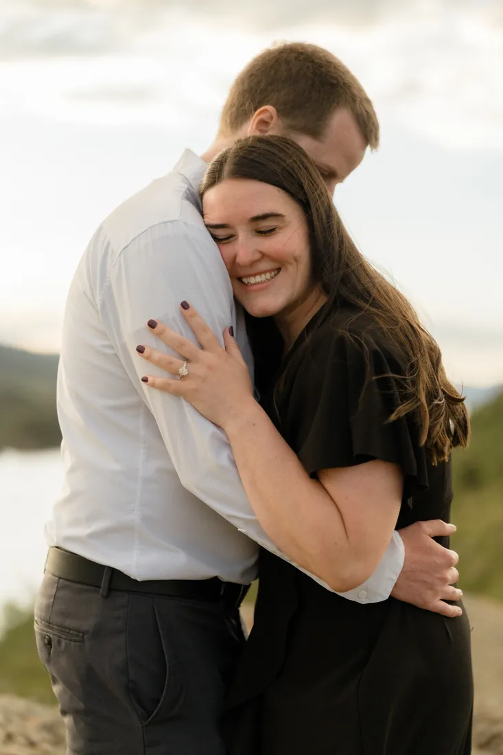 Brianna smiling while hugging Evan, her engagement ring catching the light