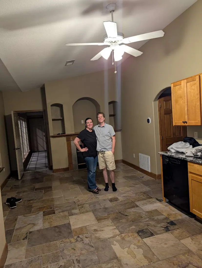 Brianna and Evan standing in the empty kitchen of their new Loveland house on moving day